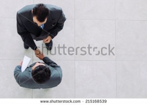 stock-photo-business-partners-shaking-hands-as-a-symbol-of-unity-view-from-the-top-215168539